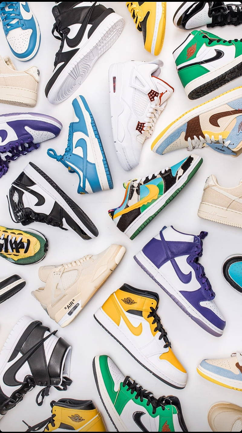 Flatlay de plusieurs sneakers Nike emblématiques alignées sur fond blanc, incluant Jordan, Dunk et Air Max